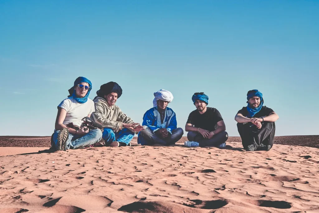Travelers and local Saharan guides together in southern Morocco