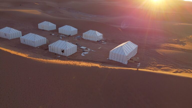 Sunburst breaking over a Sahara desert camp among the Erg Chebbi dunes
