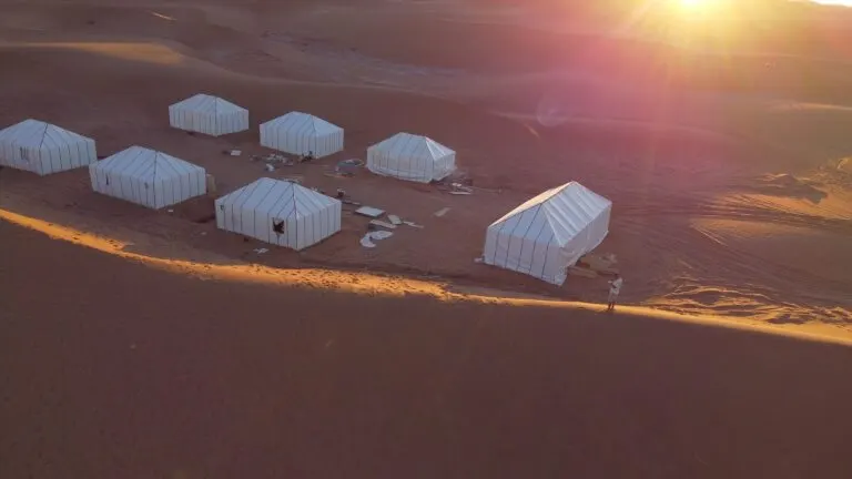 Sunburst breaking over a Sahara desert camp among the Erg Chebbi dunes