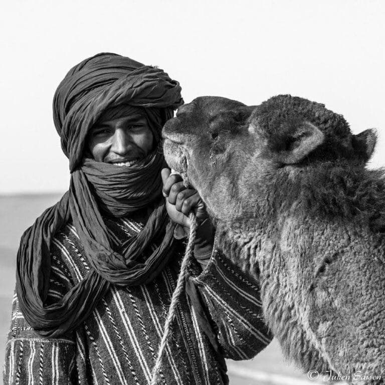 Abdessamad Maammar, founder of Sahara Explore, with a camel in the Sahara near M’hamid El Ghizlane